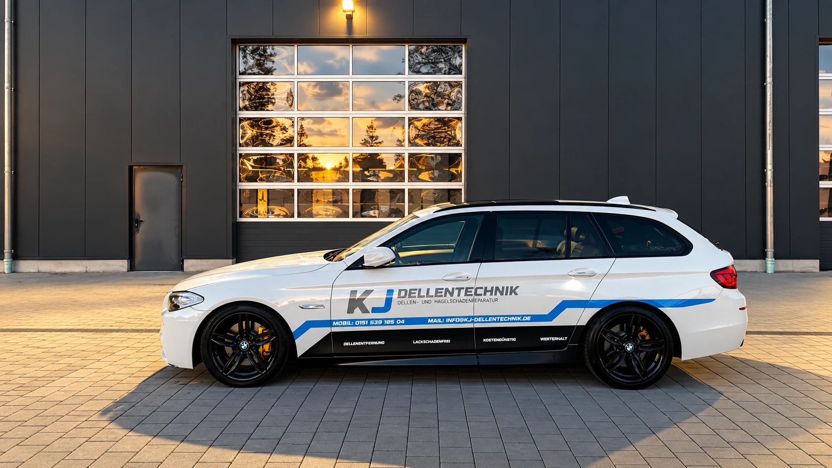 Das grau-blau beschriftete Firmenfahrzeug von KJ Dellentechnik